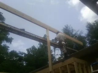 Carpenter setting a ridge beam over a new addition frame — Ice Dam Removal by Roofing Brothers in Maple Mount