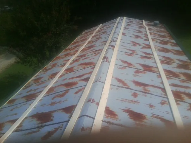 Rusted metal roof panels with new wood purlins before replacement — Storm Damage Roof Repair in Maple Mount by Roofing Brothers